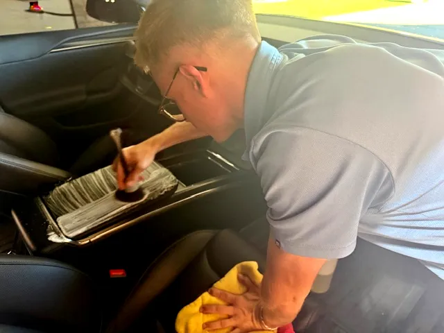 Kolbe detailing the center console during an interior detail